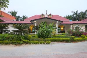 a house with a red roof and flowers at Orient Resorts in Kānpur