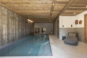 an indoor swimming pool with a wooden ceiling at Chalet Suzane - Panorama Mont-Blanc & jacuzzi in Combloux