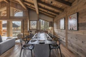 a dining room with a long table and chairs at Chalet Suzane - Panorama Mont-Blanc & jacuzzi in Combloux