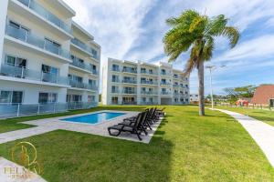 a building with a pool and a palm tree at Ideal accommodation for couples Sosúa, Santa Fe in Sosúa