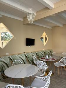 a waiting room with tables and chairs and a tv at B&B Resort El Bisagrà in Scalea