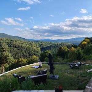 a living room with couches and a view of the mountains at Apartmani San in Plitvička Jezera