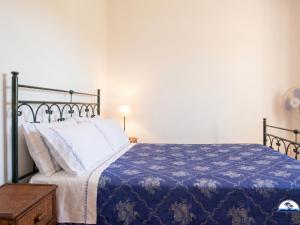 a bedroom with a bed with a blue blanket at Le Fontanelle 2 in Fontanelle