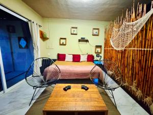 a room with a bed and two chairs and a table at Casa de vacaciones completa in Acapulco