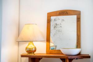 a lamp on a table next to a mirror at NEW OPENING 2026 - Là di Maur - Appartamenti in Attimis