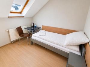 a small bedroom with a bed and a table at Pokoje Noclegowe Sierpów in Sierpów