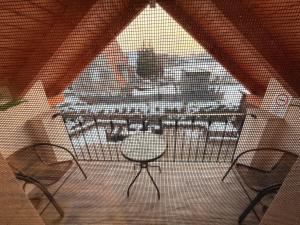 a screened in porch with two chairs and a table at VillaVino in Szekszárd