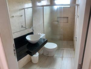 a small bathroom with a toilet and a sink at Casa de Praia do Abais in Estância