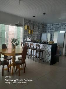 a dining room with a table and chairs in a kitchen at Casa de Praia do Abais in Estância