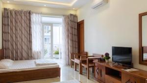 a bedroom with a bed and a tv and a window at RosePark Tuan Chau in Ha Long
