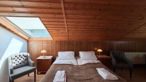 a bedroom with a bed and two chairs and a skylight at Hotel zur Post in Bacharach
