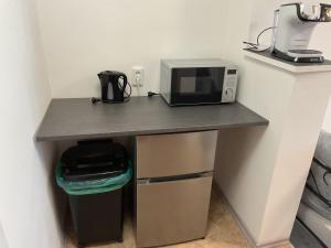 a table with a microwave and a trash can at Sierra Ferienwohnung in Marktbreit