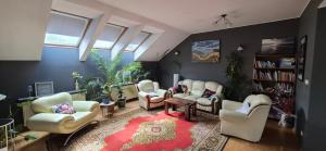 a living room with white chairs and a red rug at Apartament w Komornikach in Komorniki