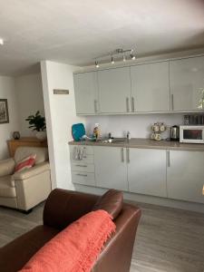 a living room with a couch and a kitchen at Gallowgate Square Apartments in Largs