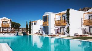 a large swimming pool in front of white buildings at Mitsis Selection Blue Domes in Kardamaina