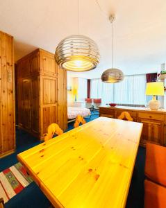 ein Esszimmer mit einem Holztisch und zwei Lampen in der Unterkunft Pila64 in Pila