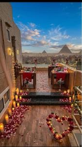 a room with tables and candles and a view of pyramids at Horus Pyramids Horizon INN in Cairo +16 photos
