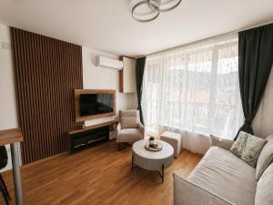 a living room with a couch and a table at Panorama Gold in Soko Banja