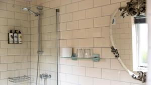 a shower in a white tiled bathroom with a window at The Crown & Horns in Newbury +46 photos