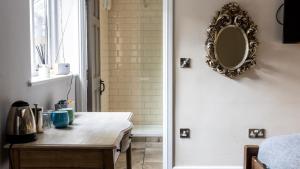 a bathroom with a table and a mirror on the wall at The Crown & Horns in Newbury