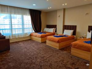 a hotel room with three beds and a window at Horus Pyramids Horizon INN in Cairo