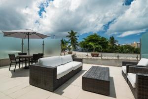 a patio with a couch and a table with an umbrella at Hotel da Bahia by Wish in Salvador
