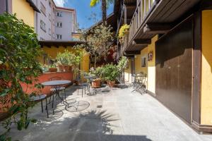 a patio with tables and chairs in a courtyard at Residenza Motta - Boutique Apartments in Locarno