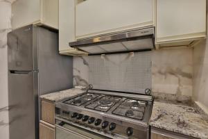 a kitchen with a stove and a refrigerator at A very, very special residential unit in Madinaty