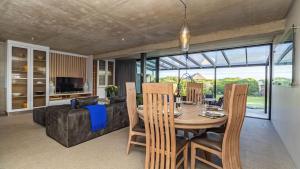 a dining room with a table and a couch at Mi Amor Beach House in Sedgefield