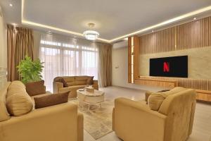 a living room with couches and a tv in a room at A very, very special residential unit in Madinaty