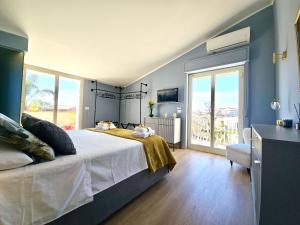 a bedroom with a bed and a large window at SuiteLina in Giardini Naxos