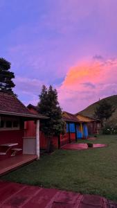 a house with a sunset in the sky at Parador Pôr do Sol in Cambará