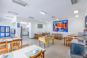 a dining room with wooden tables and chairs at HI Lagos - Pousada de Juventude in Lagos