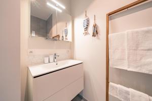 a white bathroom with a sink and a shower at Top uitzicht luxe appartement DUNES met terras POOL & GYM in Ostend +12 photos