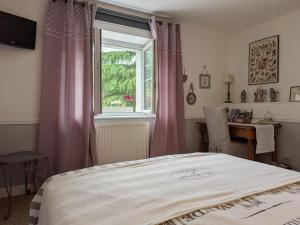 a bedroom with a bed and a window at La Grange d'Hélène in Cholet