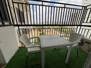 a white table and two chairs on a balcony at Magnólia Home in Muceque Baia