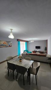 a living room with a table and chairs and a bed at Magnólia Home in Muceque Baia