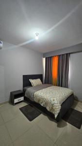 a bedroom with a bed and a window at Magnólia Home in Muceque Baia