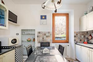a kitchen with a table with chairs and a window at Nido della Rondine in Bagnoregio +6 photos