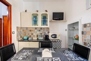 a kitchen with a table with chairs and a microwave at Nido della Rondine in Bagnoregio