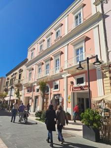 a group of people walking down a street in front of a building at Antica Dimora Petito Luxury in Matera