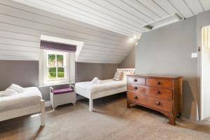 a bedroom with two beds and a dresser and a window at 2 Bed in St. Brides oc-k30489 in Saint Brides