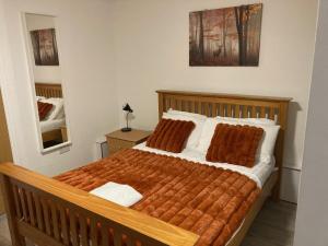 a bedroom with a large bed with brown pillows at Gallowgate Square Apartments in Largs