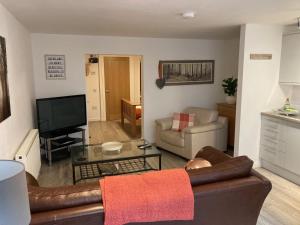 a living room with a couch and a television at Gallowgate Square Apartments in Largs
