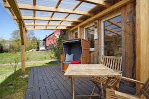 a wooden deck with a table and a pergola at Nordisch Kühl in Mariendorf