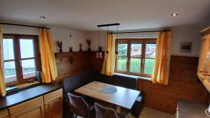 a dining room with a table and two windows at Ferienwohnung Holzer in Sankt Michael im Lungau