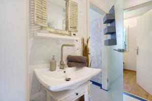 a white bathroom with a sink and a mirror at Nordisch Kühl in Mariendorf +20 photos