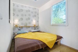 a bedroom with a bed with a yellow blanket at Nordisch Kühl in Mariendorf