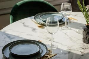 a table with plates and glasses on a marble table at Perle de Liévin in Liévin