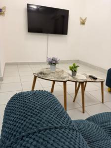 a living room with two tables and a tv at Stylish 2BR Pool, Gym Garden in Mombasa